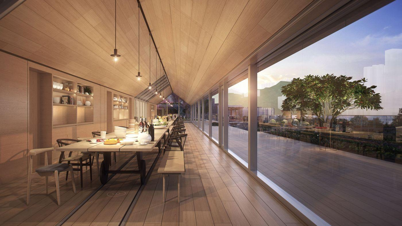 Warm timber gathering room with a long shared table and glass doors onto the terrace