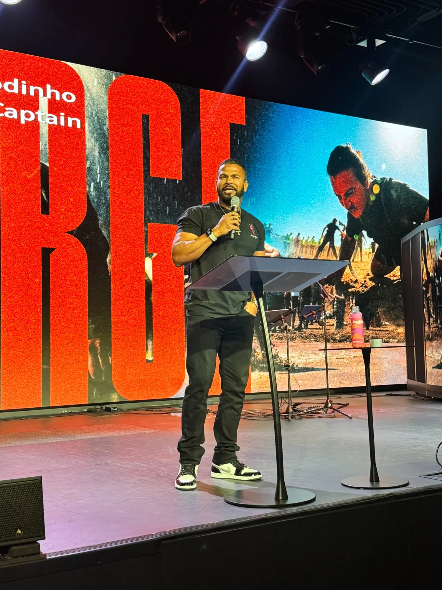 Jason Godinho preaching at an EMRG event from behind a lectern.